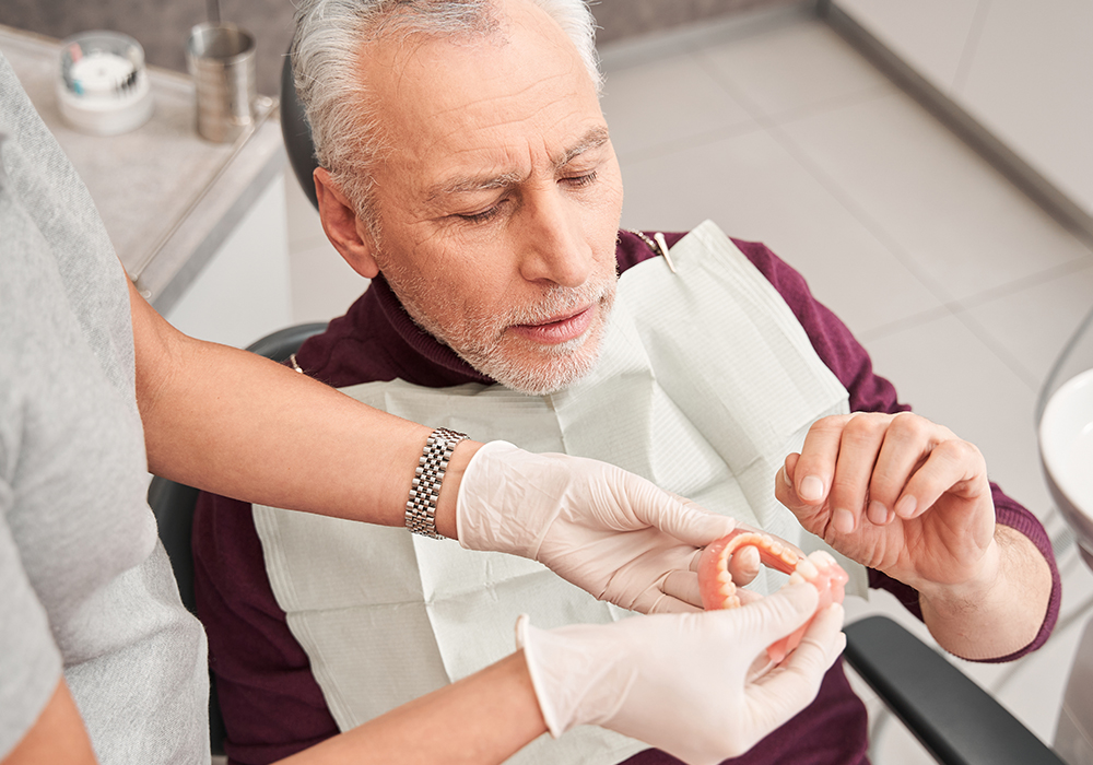 A elderly gentleman at a denture fitting consultation at a dental office.