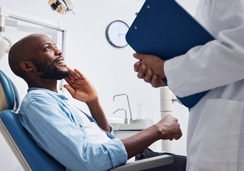 Black male speaking with dentist
