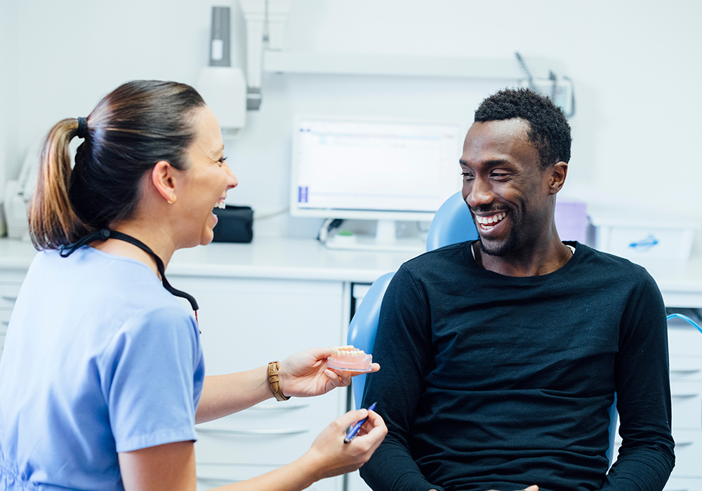 Black male speaking with dentist about dentures
