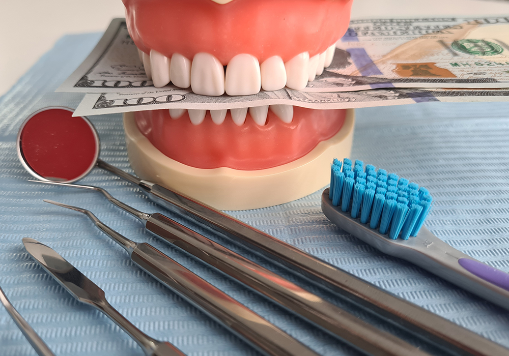 Teeth with money in-between with tool near bye