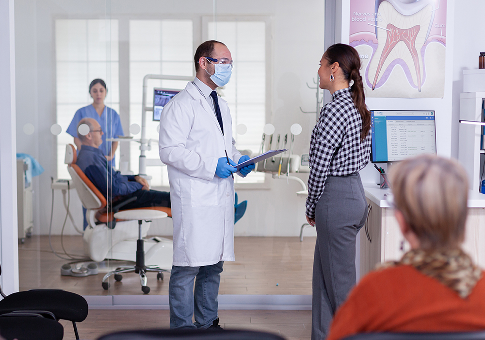 Woman speaking with a frontdesk worker in dental office