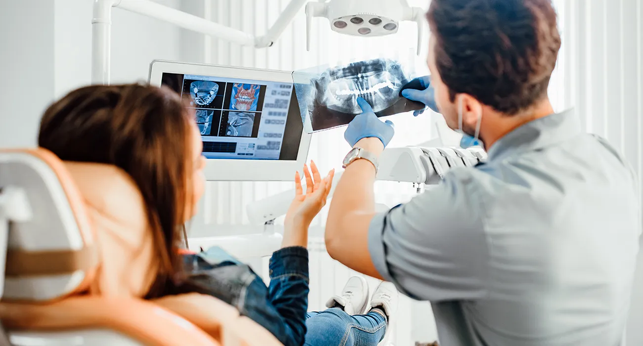 dentist showing patient x-ray of teeth