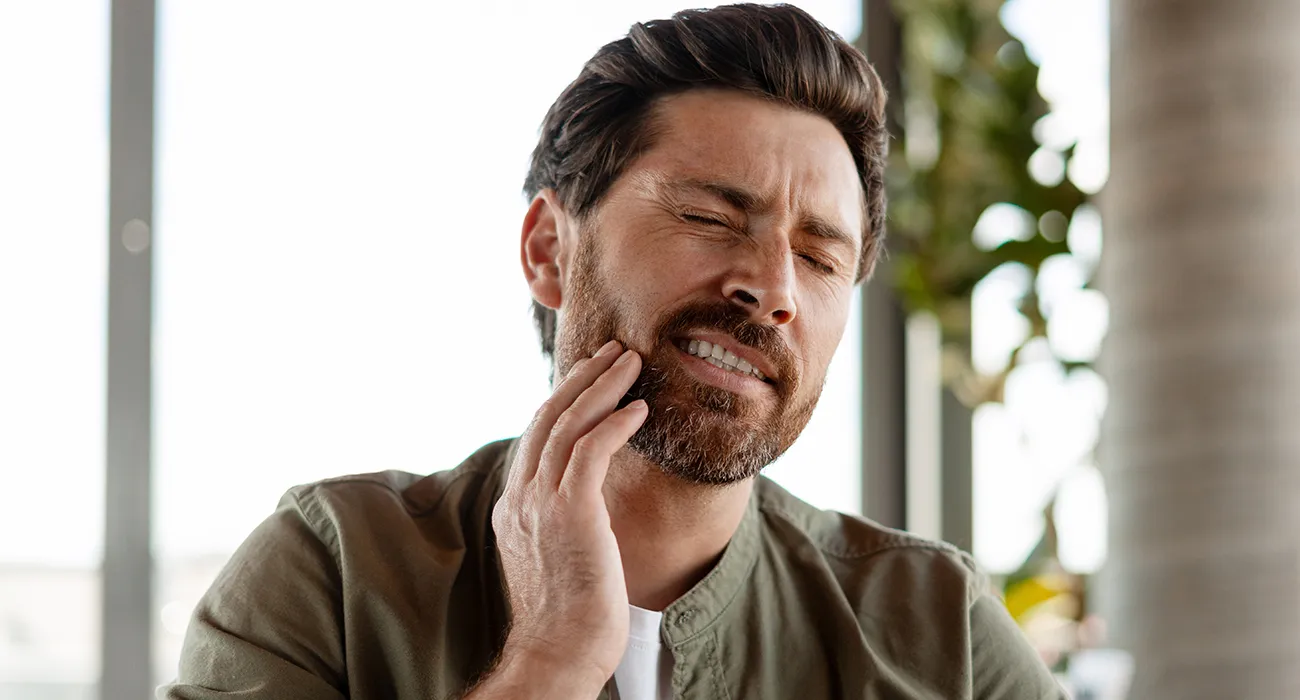 man holding jaw in pain