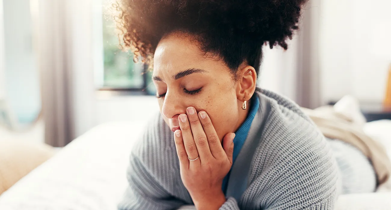 woman holding cooling pad to mouth in pain